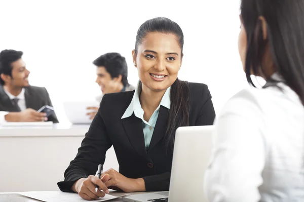 Dos empresarias discutiendo en una oficina con sus colegas — Foto de Stock