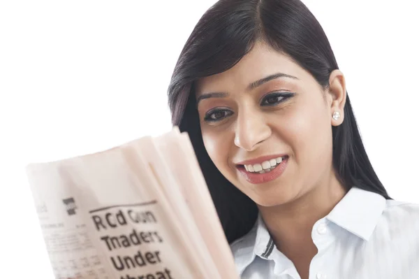 Primer plano de una mujer de negocios leyendo un periódico y sonriendo — Foto de Stock