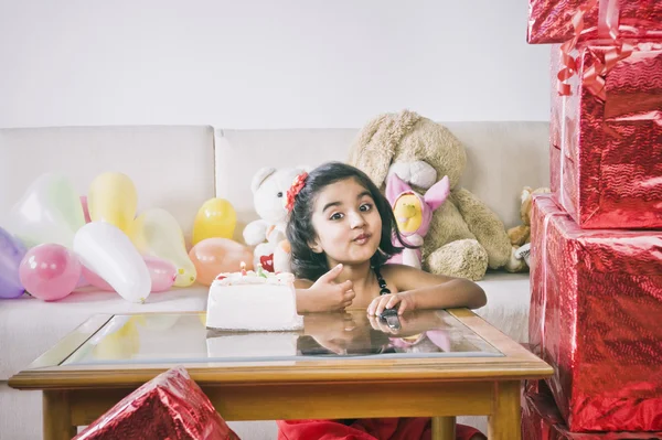 Portrait of a girl sitting in front of a cake — Stock Photo, Image