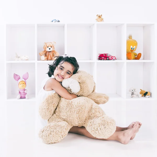 Portrait of a girl holding a teddy bear and smiling — Stock Photo, Image