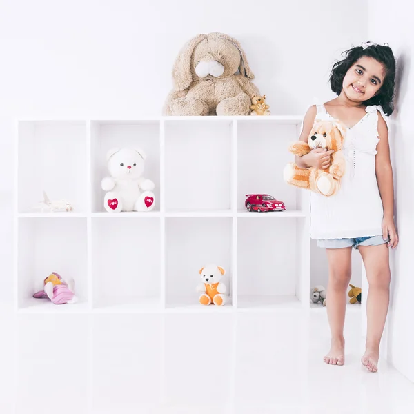 Porträtt av en flicka håller en nallebjörn och leende — Stockfoto