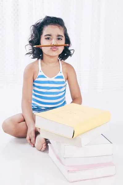 Porträtt av en flicka med en penna under hennes näsa — Stockfoto