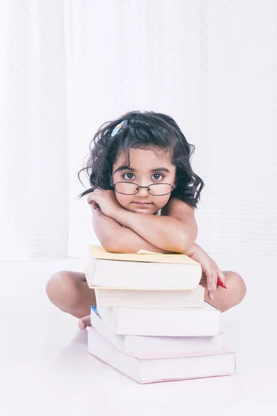 Retrato de uma menina apoiada em livros — Fotografia de Stock