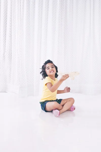 Fata se joacă cu avionul de jucărie și zâmbește — Fotografie, imagine de stoc
