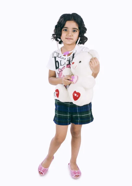 Retrato de una niña examinando un osito de peluche con un estetoscopio — Foto de Stock