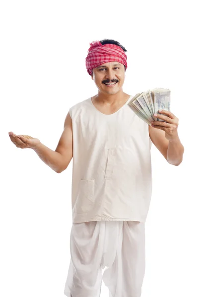 Portrait of a farmer holding money in one hand and wheat in anot — Stock Photo, Image