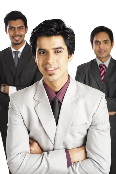 Portrait of a businessman smiling with his colleagues in the bac Stock Picture