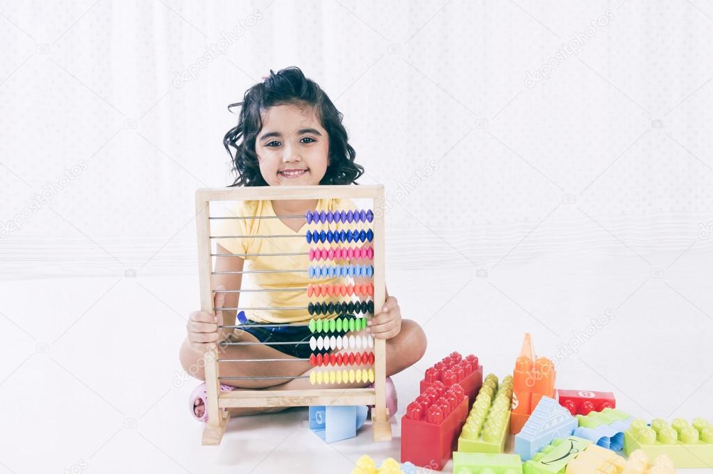 Portrait of a girl playing with abacus and smiling