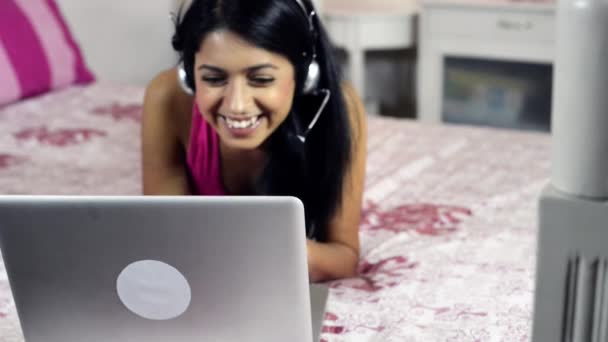 Mujer con auriculares usando laptop — Vídeos de Stock