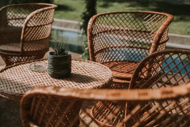 Koltuklar ve bahçe masası tencere, çiçek ve taklit deri kumaşlarla süslenmiş..