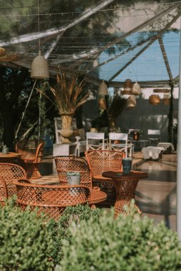 Koltuklar ve bahçe masası tencere, çiçek ve taklit deri kumaşlarla süslenmiş..