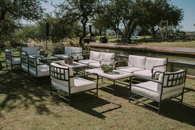 Koltuklar ve bahçe masası tencere, çiçek ve taklit deri kumaşlarla süslenmiş..