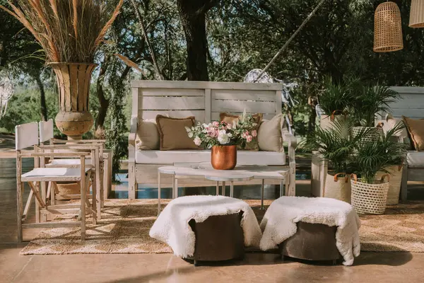 Koltuklar ve bahçe masası tencere, çiçek ve taklit deri kumaşlarla süslenmiş..