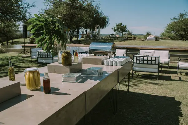 Koltuklar ve bahçe masası tencere, çiçek ve taklit deri kumaşlarla süslenmiş..