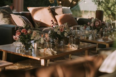 Kişisel bardakları, mumları ve çiçekleri olan ahşap bir masa. Sosyal etkinlikler için dekorasyon.