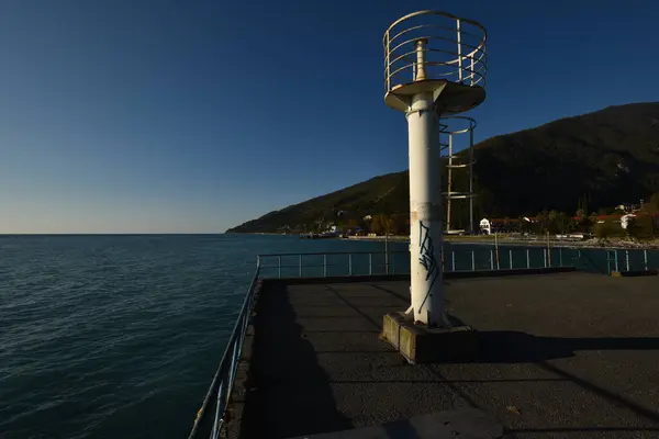 Okyanusa bakan bir iskelede deniz feneri kulesi.