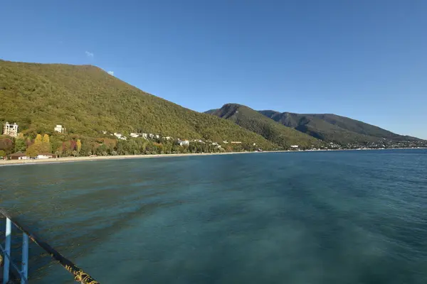 a view of a beach and mountains from a boat