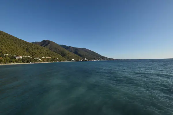 a view of a beach and mountains from a boat
