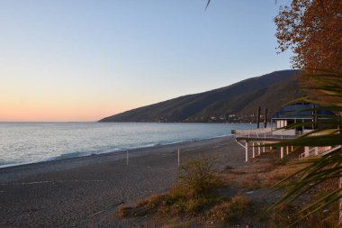 Arka planda bir dağ ve iskelesi olan bir sahil.