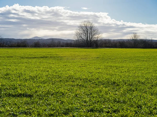 Montaña detrás de un campo después de una tormenta.. —  Fotos de Stock