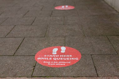 Mağazadaki tabela müşterilere 2 metre güvenli sosyal mesafeyi korumalarını söylüyor, Covid 19 salgın kısıtlaması