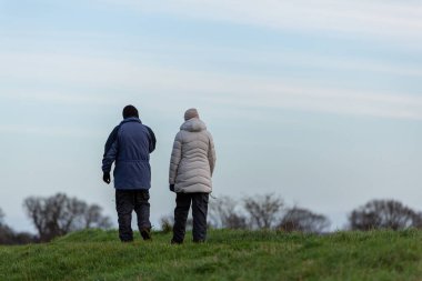 Bilinmeyen bir çift soğuk bir kış gününde güzel Suffolk kırsalında yürüyüş yapıyor.
