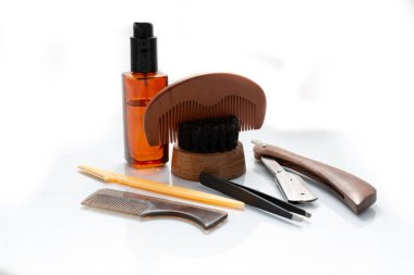 Yağ, jilet ve fırça gibi temiz beyaz bir arkaplana karşı çekilen erkek sakalı yetiştirme ürünleri.