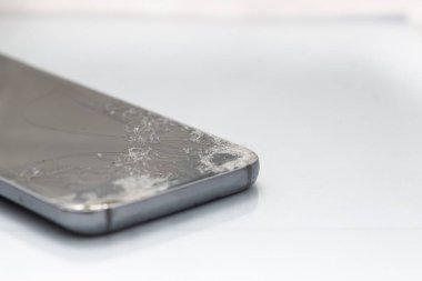 Akıllı telefondaki kırık cam ekranı kapat, beyaz arka planda izole edilmiş.