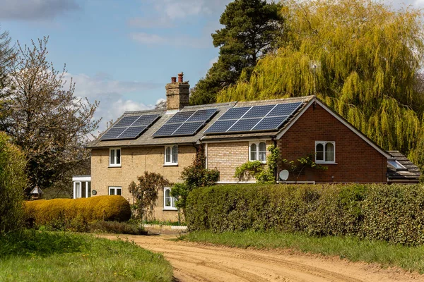 Woodbridge, Suffolk, İngiltere 1 Mayıs 2021: Temiz yeşil yenilenebilir enerji üretmek için çatıya güneş panelleri kurulmuş bir kır evi
