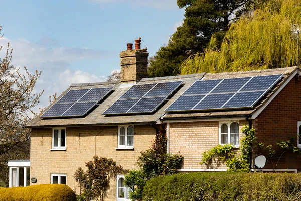 Woodbridge, Suffolk, İngiltere 1 Mayıs 2021: Temiz yeşil yenilenebilir enerji üretmek için çatıya güneş panelleri kurulmuş bir kır evi
