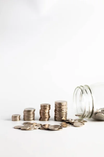 Coins stacked up next to an empty jar with a label on for pension fund. Pension, financial, savings, economy, investment concept