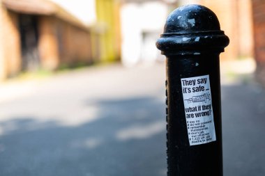 Woodbridge Suffolk UK July 21 2021: An anti vaccination sticker that has been stuck and littered around a town centre spreading disinformation about the pandemic and vaccines