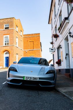 Woodbridge Suffolk İngiltere 11 Ağustos 2021: Suffolk 'ta Woodbridge' de popüler bir otelin önünde park etmiş 2021 model elektrikli Porsche Taycan Turbo
