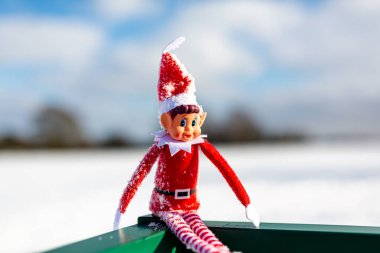 Woodbridge Suffolk Birleşik Krallık 11 Şubat 2021: Yaramaz bir Noel elfi dışarıda karlı kış manzarasında kış güneşinin tadını çıkarıyor. Yaramaz, noel, yaramaz elf konsepti