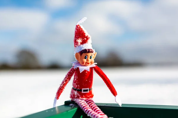Woodbridge Suffolk Birleşik Krallık 11 Şubat 2021: Yaramaz bir Noel elfi dışarıda karlı kış manzarasında kış güneşinin tadını çıkarıyor. Yaramaz, noel, yaramaz elf konsepti