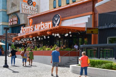 Nevada, ABD 10-01-18 Bir grup turist New York-New York Las Vegas otelini çevreleyen yoğun kaldırım boyunca modern ve sıradan Tom 's Urban restoranının önünde yürüyor.