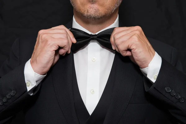 Gentleman in Black Tie Straightens His Bowtie — Stock Photo, Image