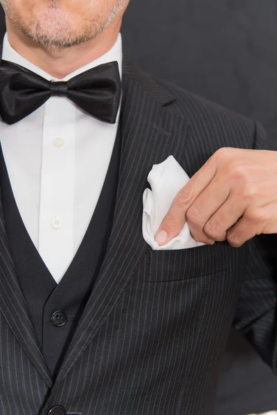 Gentleman in Black Tie Fixes Pocket Square, vertical — Photo