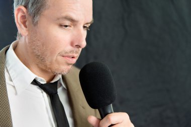 Ciddi adam mikrofona konuşur