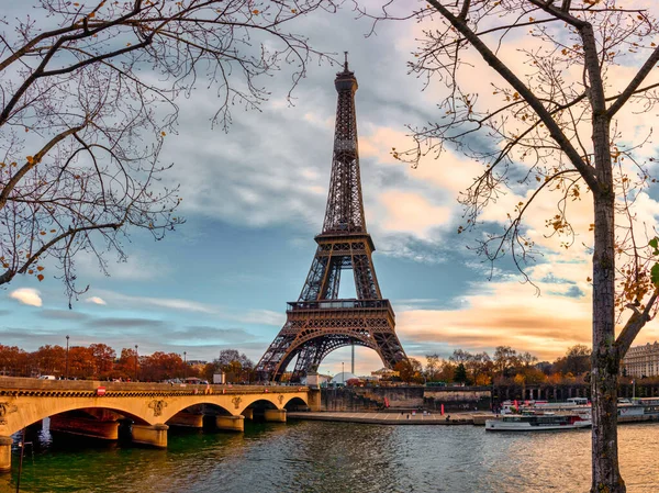 Sonbaharda Paris şehri. Gemiler ve tugaylar Seine nehri üzerinde Eyfel kulesiyle arka planda ve dramatik bulutlu gökyüzünde.