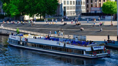 Berlin 'de Spree nehrinde turistlerle dolu bir tekne gezisi.