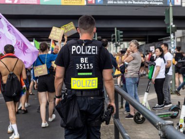 Berlin, Almanya - 26 Haziran 2021 - Berlin 'de düzenlenen Kristof Sokağı (CSD) gösterisinin oturum aralarında bir polis memurunun arka görüntüsü