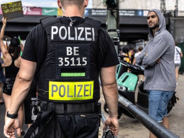 Berlin, Almanya - 26 Haziran 2021 - Gösterinin oturum aralarında bir polis memurunun arka görüntüsü