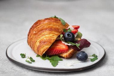 Peynirli, roka ve böğürtlenli kruvasan sandviç..