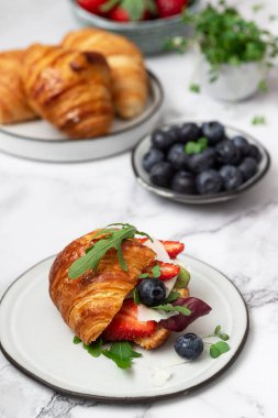 Peynirli, roka ve böğürtlenli kruvasan sandviç..