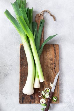 Çiftlik taze organik pırasa, tahta üzerinde bahar salatası malzemesi.