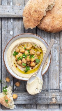 Bir tabak maydanozlu ve pide ekmekli klasik humus. Geleneksel humus salatası