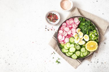 Taze salatalıklı salata, turp, otlar, kasede limon. Sağlıklı beslenme kavramı. Vejetaryenler için yiyecek..