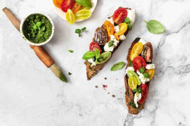 Domatesli sandviç, burrata peyniri ve pesto. Geleneksel - ızgara bruschetta tostları.