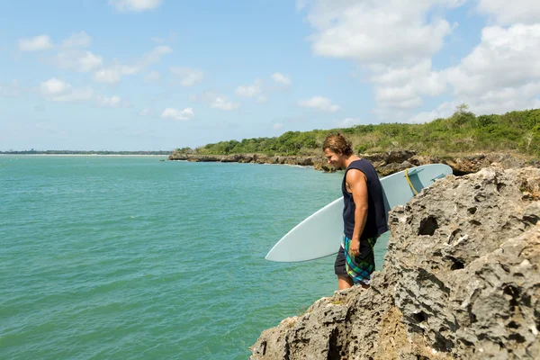 Surfer jumps off a cliff into the ocean. Indonesia Bali — Stock Photo, Image